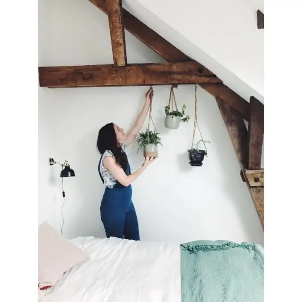 Woman hanging a plant on the ceiling